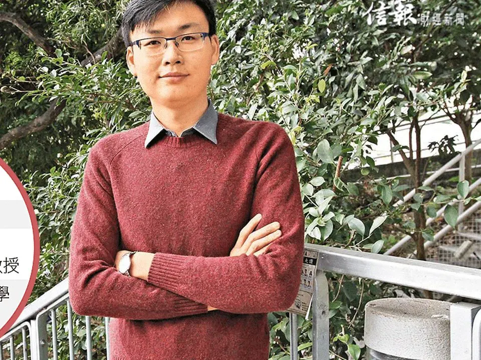 Professor Yen Joe Tan standing with his arms folded on a balcony, trees behind him.